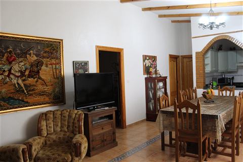 Salón con TV y arco de ladrillo